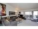 Living room with gray sectional sofa, coffee table, and access to balcony at 9707 E Mountain View Rd # 2430, Scottsdale, AZ 85258