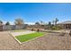 Backyard featuring artificial turf and a stone patio with an iron fence at 1081 E Lowell Ct, Gilbert, AZ 85295