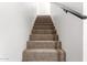 Carpeted stairs with white walls and handrail at 124 E Beech Ave, Casa Grande, AZ 85122