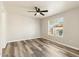 This bedroom features a ceiling fan, wood-look flooring, and a window providing natural light at 12459 W Benito Dr, Arizona City, AZ 85123