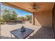 Covered patio area features a ceiling fan, a stone table, and views of desert landscaping at 12541 W Miner Trl, Peoria, AZ 85383