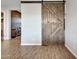 Living area with wood-look tile flooring and a stylish sliding barn door at 12576 W Oyer Ln, Peoria, AZ 85383