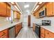 Efficient galley kitchen with wood cabinets, updated appliances, and skylight at 14237 N Westminster Pl, Fountain Hills, AZ 85268