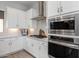 Modern kitchen with white cabinets, stainless steel appliances, and a gas cooktop at 18402 N 65Th Pl, Phoenix, AZ 85054