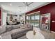 Open living room showcasing a comfortable sectional sofa, stylish coffee table, and views to the kitchen and pool at 18402 N 65Th Pl, Phoenix, AZ 85054