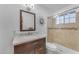 Bathroom featuring a marble countertop, dark vanity, and a glass shower at 2011 W Cambridge Ave, Phoenix, AZ 85009