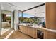 Wet bar with marble countertop, wine cooler, and view of backyard oasis at 27951 N 96Th Pl, Scottsdale, AZ 85262