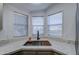 Bright kitchen sink nook featuring a dark faucet, light countertops and three sunny windows at 3104 E Broadway Rd # 16, Mesa, AZ 85204