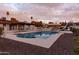 Backyard swimming pool and slide offers outdoor fun against a vibrant desert sunset at 4015 E Emelita Ave, Mesa, AZ 85206