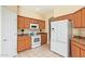 Kitchen with light wood cabinets, white appliances, and tile floors at 4337 W Powell Dr, Phoenix, AZ 85087