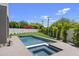 Relaxing backyard with a stylish pool and spa, surrounded by green lawn and tasteful landscaping at 4445 E Roma Ave, Phoenix, AZ 85018