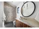 Modern bathroom boasts a tiled shower, stylish vanity with a vessel sink, and a sleek, round mirror at 4445 E Roma Ave, Phoenix, AZ 85018