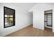 Bedroom featuring wood floors, white walls, large window and a walk in closet at 4445 E Roma Ave, Phoenix, AZ 85018