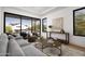 Bright living room featuring comfortable seating, round tables, and large sliding glass doors with neighborhood views at 4445 E Roma Ave, Phoenix, AZ 85018