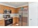 Well-lit kitchen features stainless steel appliances, wood cabinetry, and an adjacent door for easy access at 8418 W Almeria Rd, Phoenix, AZ 85037