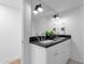 Bright bathroom features double sinks, a dark countertop, white cabinets, and stylish decorative accents at 9136 N 81St St, Scottsdale, AZ 85258