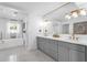 Bright bathroom showcasing double vanity, grey cabinets, modern fixtures, mosaic tile floor and soaking tub at 9136 N 81St St, Scottsdale, AZ 85258