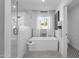 Modern bathroom featuring walk-in shower, soaking tub, mosaic tile floor and natural light at 9136 N 81St St, Scottsdale, AZ 85258
