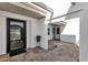 Stylish home entrance with a modern black door, tiled patio, and sleek landscaping features at 9136 N 81St St, Scottsdale, AZ 85258