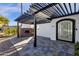 Modern home's entrance features a pergola, fireplace, and a sleek, black front door at 9136 N 81St St, Scottsdale, AZ 85258