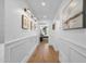 Well-lit hallway features wood floors, decorative wall art, wainscoting, and a view into the bedroom at 9136 N 81St St, Scottsdale, AZ 85258