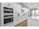 Bright kitchen features white cabinets, stainless steel appliances, marble countertops, and wood flooring at 9136 N 81St St, Scottsdale, AZ 85258