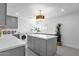 Spacious laundry room features gray cabinets, an island, a sink, stainless steel washer/dryer, and modern flooring at 9136 N 81St St, Scottsdale, AZ 85258
