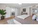 Modern main bedroom features sliding barn door to bathroom, light wood floors, and coffered ceiling at 9136 N 81St St, Scottsdale, AZ 85258