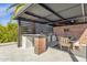 Outdoor kitchen boasts brick accents, grill, ceiling fan and dining area under a covered patio at 9136 N 81St St, Scottsdale, AZ 85258