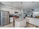 Bright kitchen with island, pendant lighting, stainless steel refrigerator, white cabinets, and bar stool seating at 10255 W Townley Ave, Peoria, AZ 85345