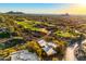Expansive aerial view of a desert home situated near a lush green golf course with mountain views at 1084 N Boulder Dr, Carefree, AZ 85377
