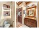 Rustic bathroom with wood vanity, decorative mirror, and walk-in shower with glass doors at 1084 N Boulder Dr, Carefree, AZ 85377