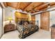 Cozy bedroom featuring beamed ceilings, shutters, rustic door and decorative iron bed frame at 1084 N Boulder Dr, Carefree, AZ 85377