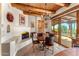 Inviting dining area with rustic wood ceiling beams, fireplace, and seamless indoor-outdoor flow at 1084 N Boulder Dr, Carefree, AZ 85377