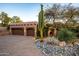 Exterior shot of property, featuring large garage with adobe accents and desert landscaping at dusk at 1084 N Boulder Dr, Carefree, AZ 85377