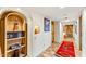 Hallway features built in bookshelf with arched trim and tiled floors with rug at 1084 N Boulder Dr, Carefree, AZ 85377