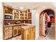 Cozy kitchenette with wood cabinets, tile countertops and shelving alcove at 1084 N Boulder Dr, Carefree, AZ 85377