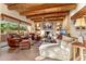 Spacious living room with a cozy fireplace, leather furniture, and flagstone floors at 1084 N Boulder Dr, Carefree, AZ 85377