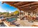 Inviting covered patio with flagstone flooring, outdoor dining, and a sparkling pool overlooking the desert landscape at 1084 N Boulder Dr, Carefree, AZ 85377