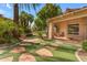 Backyard view highlights a lush green artificial lawn and stone-laid walkway to patio at 11505 E Cochise Dr, Scottsdale, AZ 85259