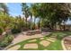 Landscaped backyard with a fire pit, spa, and lush plantings at 11505 E Cochise Dr, Scottsdale, AZ 85259