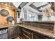 Custom bar area showcasing granite countertops, decorative cabinetry, and a unique design at 11505 E Cochise Dr, Scottsdale, AZ 85259
