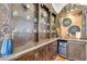 Elegant bar area with decorative shelving, glassware, and a convenient ice maker for entertaining at 11505 E Cochise Dr, Scottsdale, AZ 85259