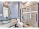 Modern bathroom with a glass-enclosed shower, gray tile and neutral walls at 11505 E Cochise Dr, Scottsdale, AZ 85259