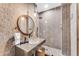 Modern bathroom with a stone tiled shower, glass sink and stylish mirror at 11505 E Cochise Dr, Scottsdale, AZ 85259