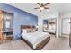 Bright bedroom with a blue accent wall, wood furniture, and doorway to Primary bathroom at 11505 E Cochise Dr, Scottsdale, AZ 85259