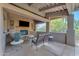 Inviting covered patio featuring a stone fireplace, comfortable seating, and serene outdoor ambiance at 11505 E Cochise Dr, Scottsdale, AZ 85259