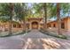 Elegant home with a grand entrance, mature landscaping, and a welcoming walkway at 11505 E Cochise Dr, Scottsdale, AZ 85259