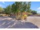 Lush trees surrounding a home with a circular driveway and meticulously maintained landscape at 11505 E Cochise Dr, Scottsdale, AZ 85259