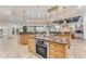 Spacious kitchen featuring an island with a sink, oven, wood cabinets, and tile flooring at 11505 E Cochise Dr, Scottsdale, AZ 85259